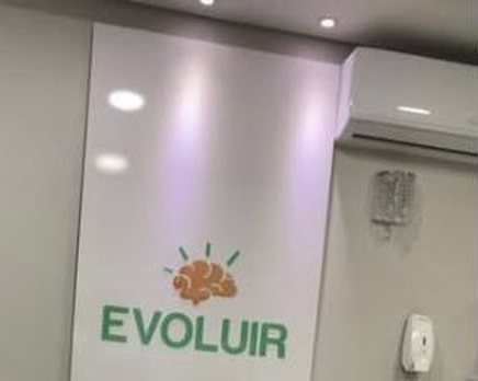 Recepção da Evoluir com o logo da clínica na parede